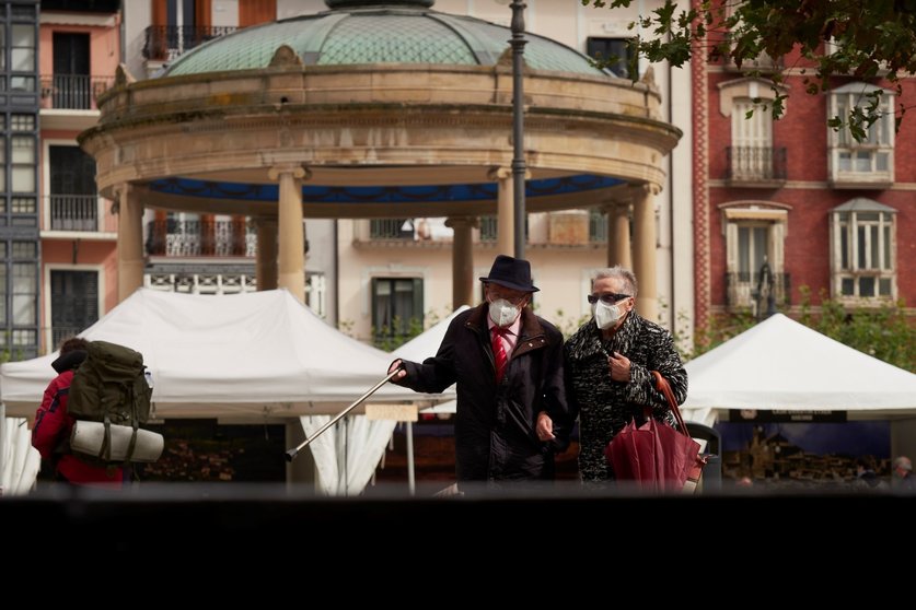 Transeúntes pasean por una calle de Pamplona protegidos con mascarilla debido a la crisis sanitaria del Covid-19, en Pamplona, Navarra, (España), a 11 de octubre de 2020.
