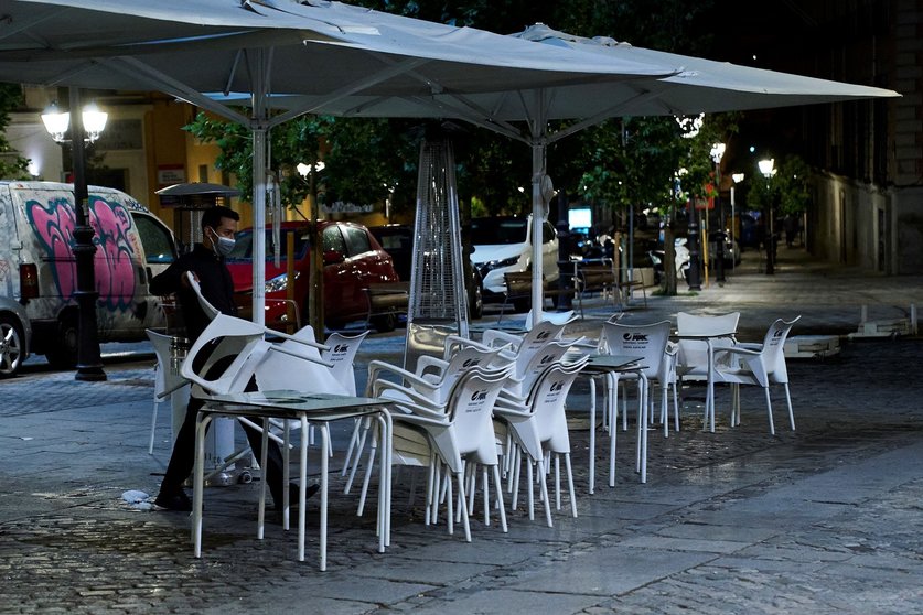 Una persona recoge la terraza de una cafetería en Madrid durante la primera jornada en la que se permite el cierre a la 01.00 en hostelería y recintos culturales, a 31 de mayo de 2021, en Madrid (España). La ampliación de horarios hasta la 01.00 horas en 