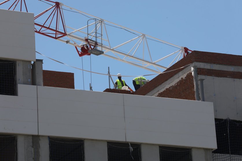 Archivo - Dos obreros trabajan en la construcción de un edificio