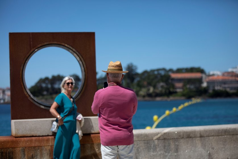 Un hombre echa una foto a una mujer en el paseo marítimo de la playa de Sanxenxo, a 4 de junio de 2021, en Sanxenxo, Pontevedra, Galicia, (España). El aumento de las temperaturas y la progresiva mejora de la situación epidemiológica ha colaborado en que l