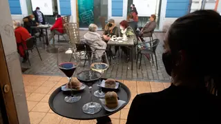 Una camarera se dispone a servir en una terraza de un restaurante