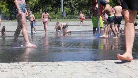 Varias personas, entre ellas ni&ntilde;os, se refrescan en los chorros de Madrid R&iacute;o un d&iacute;a antes de que, seg&uacute;n la Agencia Estatal de Meteorolog&iacute;a (AEMET), llegue a la pen&iacute;nsula Ib&eacute;rica y a las Islas Baleares la primera ola de calor del verano 2019.