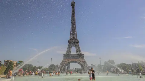 28 June 2019, France, Paris: People enjoy the water at the Trocadero Fountain in front of the Eiffel Tower during a heat wave. Photo: Vanessa Carvalho/ZUMA Wire/dpa