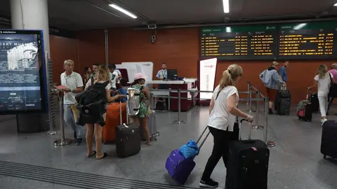 Varios pasajeros se aproximan a una oficina de venta de billetes de &uacute;ltima hora en la estaci&oacute;n de tren Puerta de Atocha de Madrid durante la primera de las cuatro jornadas de paros parciales de Renfe a los que el sindicato CGT ha convocado a los trabajado