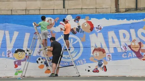 Ni&ntilde;os realizando un mural en la pista deportiva de La Marisma en Astillero