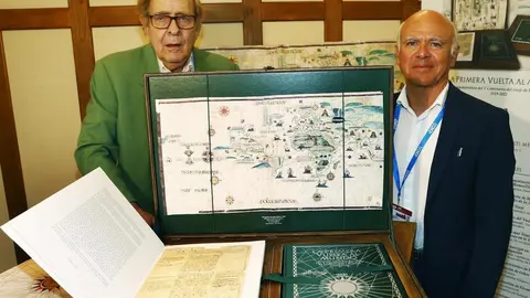 Jos&eacute; Mar&iacute;a Sanz Hermida y Ram&oacute;n Tamames con una copia de las ilustraciones de 'La Primera Vuelta la Mundo'