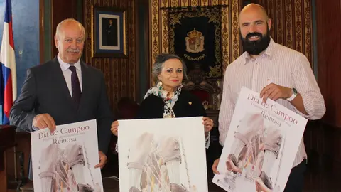 El alcalde de Reinosa, Jos&eacute; Miguel Barrio, Alicia Ca&ntilde;as y el concejal de Festejos, Daniel Santos, junto al cartel del Dia de Campoo.