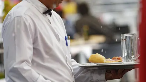 Un camarero porta una bandeja en un bar de Madrid.
