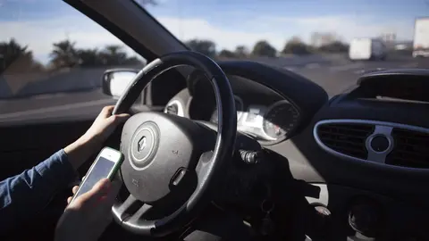 Un conductor con tel&eacute;fono m&oacute;vil