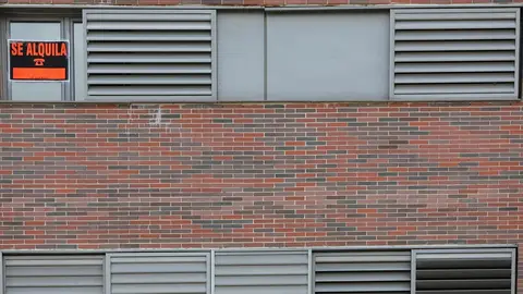 En la ventana de un piso se ve colgado un cartel en el que se lee 'Se alquila'.
