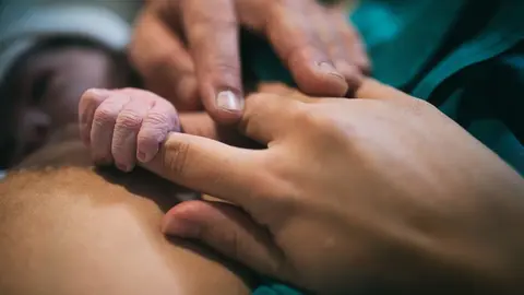 Un reci&eacute;n nacido junto a su madre.