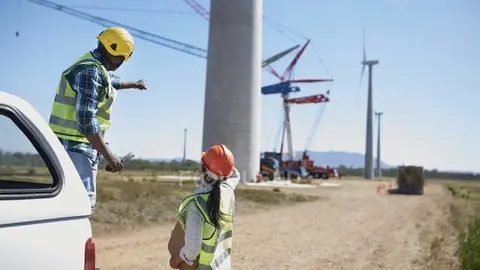 focused_211790148-stock-photo-engineers-dirt-road-wind-turbine