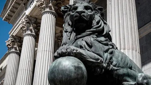 Uno de los emblem&aacute;ticos leones que se encuentran delante de la fachada del Congreso de los Diputados en la Plaza de las Cortes de Madrid.