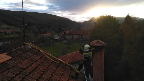 Bomberos del 112 atendiendo el incendio de una chimenea en una casa de Mazcuerras