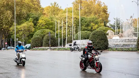 Dos motoristas circulan con lluvia en la rotonda de la Fuente de Neptuno durante el peor temporal del oto&ntilde;o del 2019 en Espa&ntilde;a en el que se ver&aacute;n afectadas 37 provincias avisadas por viento, nieve, oleaje o lluvia, en Madrid (Espa&ntilde;a) a 14 de noviembre de 