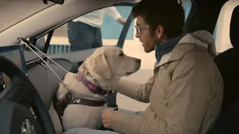 Una persona ciega, con discapacidad visual, usa viaja como copiloto en un coche de Cabify.