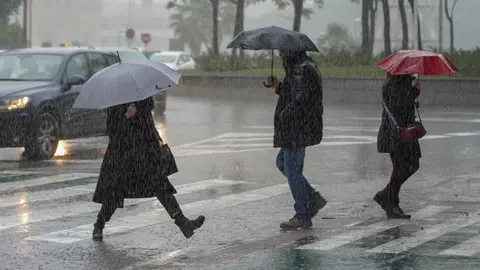 Peatones bajo la lluvia en Sevilla (Imagen de archivo)