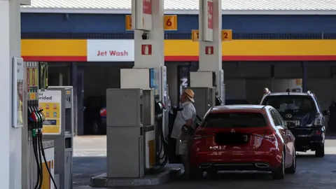 Personas ponen gasolina en sus coches en una gasolinera de Madrid.