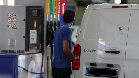 Personas ponen gasolina en sus coches en una gasolinera de Madrid.