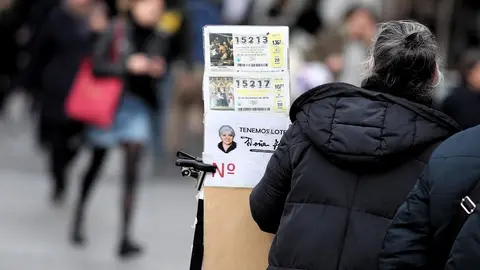 Una lotera junto a su puesto de venta de boletos de Loter&iacute;a de Navidad en la Plaza del Sol de Madrid (Espa&ntilde;a), a 16 de diciembre de 2019 .