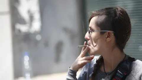 Mujer fumando un cigarro.