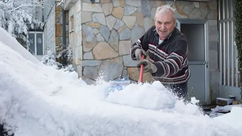 Un vecino de la localidad retira la nieve de su veh&iacute;culo, en el municipio de  Pedrafita do Cebreiro, en Lugo-Pa&iacute;s Vasco (Espa&ntilde;a), a 17 de diciembre de 2019.