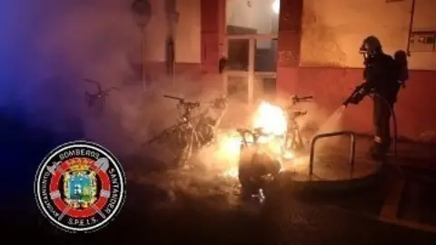 Los bomberos tratan de sofocar el incendio de las motos