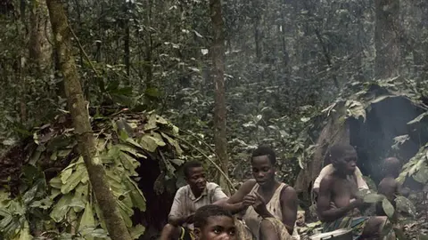 DZANGA SANGHA,CAR - JULY 2018: A Baaka family group during one of their hunting days rests in their camp in the jungle. The Baakas are pygmies. They are considered second-class citizens in RCA. They suffer constant violations of their fundamental rights and in many cases they work in a semi-slavery regime for other ethnic groups living in the country.