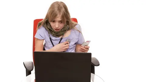 Hypochondria - Young Female checking herself with a stethoscope and searching information about her disease on a laptop.