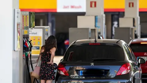 Personas ponen gasolina en sus coches en una gasolinera de Madrid.