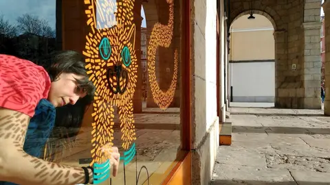 Una alumna de la Escuela de Arte interviene en un escaparate