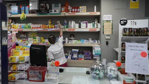 Imagen de una farmac&eacute;utica cogiendo un medicamento      