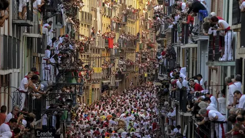 Participants run in front of Alcurrucen's bulls during the first bull run of the San Fermin Festival, on July 7, 2013, in Pamplona, northern Spain. The festival is a symbol of Spanish culture that attracts thousands of tourists to watch the bull runs despite heavy condemnation from animal rights groups. AFP PHOTO/ PEDRO ARMESTRE