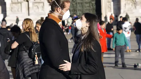 Una pareja de turistas con mascarillas en la ciudad italiana de Pisa.