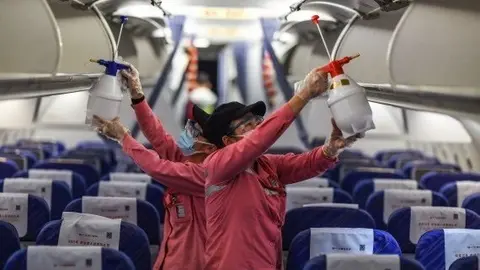 Empleados desinfectan la cabina de un avi&oacute;n despu&eacute;s de su llegada al Aeropuerto Internacional de Haikou Meilan, provincia de Hainan, en el sur de China.
