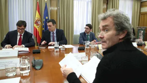 El ministro de Sanidad, Salvador Illa (1i), habla con el presidente del Gobierno, Pedro S&aacute;nchez (2i), acompa&ntilde;ados del director del Centro de Coordinaci&oacute;n de Alertas y Emergencias Sanitarias del Ministerio de Sanidad, Fernando Sim&oacute;n (frente a S&aacute;nchez)