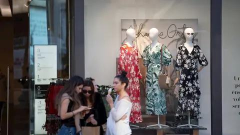 Unas j&oacute;venes con bolsas de la marca Bershka y frente a un establecimiento de la misma cadena en Barcelona el d&iacute;a en que el grupo Inditex (al que pertenece Bershka) ha cerrado sus tiendas en Madrid, La Rioja y Miranda de Ebro. En Barcelona (Catalunya, Espa