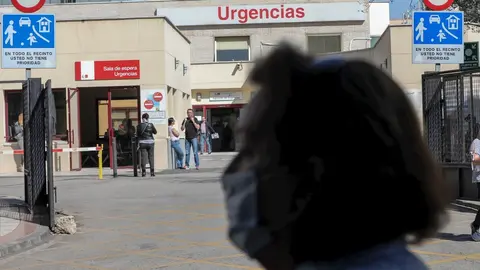 Una mujer protegida con mascarilla pasea cerca de la puerta de Urgencias del Hospital Gregorio Mara&ntilde;&oacute;n, un d&iacute;a despu&eacute;s de que el presidente del Gobierno, Pedro S&aacute;nchez, declarase el Estado de Alarma debido a la crisis del coronavirus en Espa&ntilde;a, en Madrid 