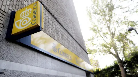 Cartel de Correos de Madrid en lo alto de una oficina de Correos