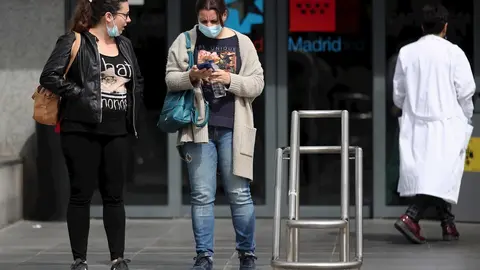 Dos mujeres protegidas con mascarilla a las afueras del Hospital de la Paz donde se ha habilitado un espacio para atender "en mejores condiciones" a pacientes sospechosos de coronavirus, en Madrid (Espa&ntilde;a), a 12 de marzo de 2020.