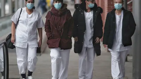 Cuatro trabajadoras sanitarias protegidas con mascarilla.