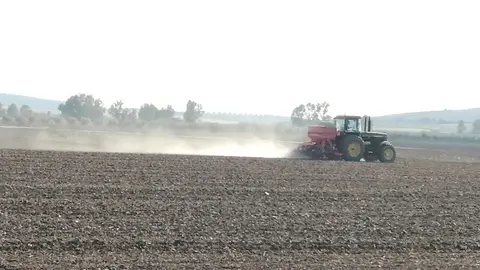 Un agricultor trabaja con su tractor en el campo.
