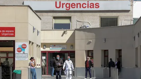 Varias personas protegidas con mascarilla se encuentran cerca de la puerta de Urgencias del Hospital Gregorio Mara&ntilde;&oacute;n (Madrid).