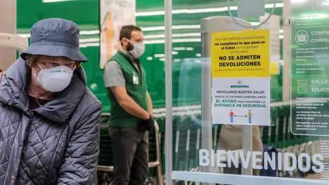Una mujer con mascarilla a las puertas de un Mercadona