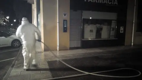 Efectivos del plan de limpieza y desinfecci&oacute;n trabajan en el exterior de una farmacia