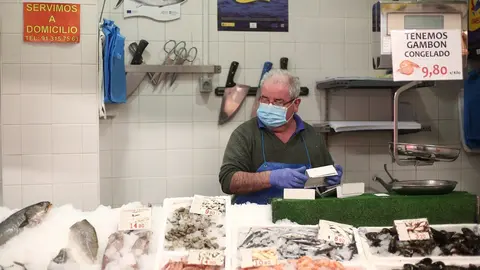 Un trabajador del Mercado municipal Barcel&oacute; ordena los productos alimenticios en su puesto de trabajo en plena crisis del coronavirus.