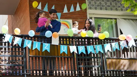 Una familia saluda desde la terraza en Sevilla 
