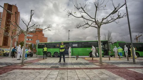 Polic&iacute;as militares escoltan uno de los autobuses cuyos pasajeros son pacientes contagiados con coronavirus