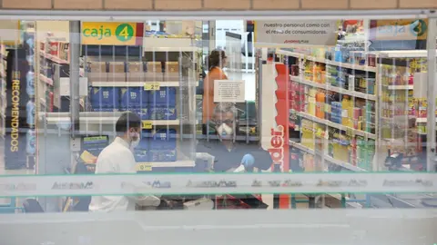 Un cajero de un supermercado AhorraMas trabaja protegido con mascarilla en plena crisis sanitaria por coronavirus donde los espa&ntilde;oles llevan confinados en sus hogares m&aacute;s de una semana.