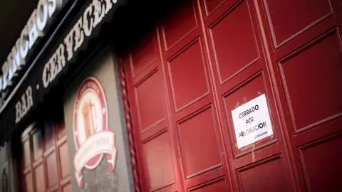 Entrada cerrada de un bar de Madrid en el que un cartel dice 'Cerrado por precauci&oacute;n' un d&iacute;a antes de que se cierre toda la hosteler&iacute;a para frenar contagios por coronavirus, en Madrid (Espa&ntilde;a) a 13 de marzo de 2020.